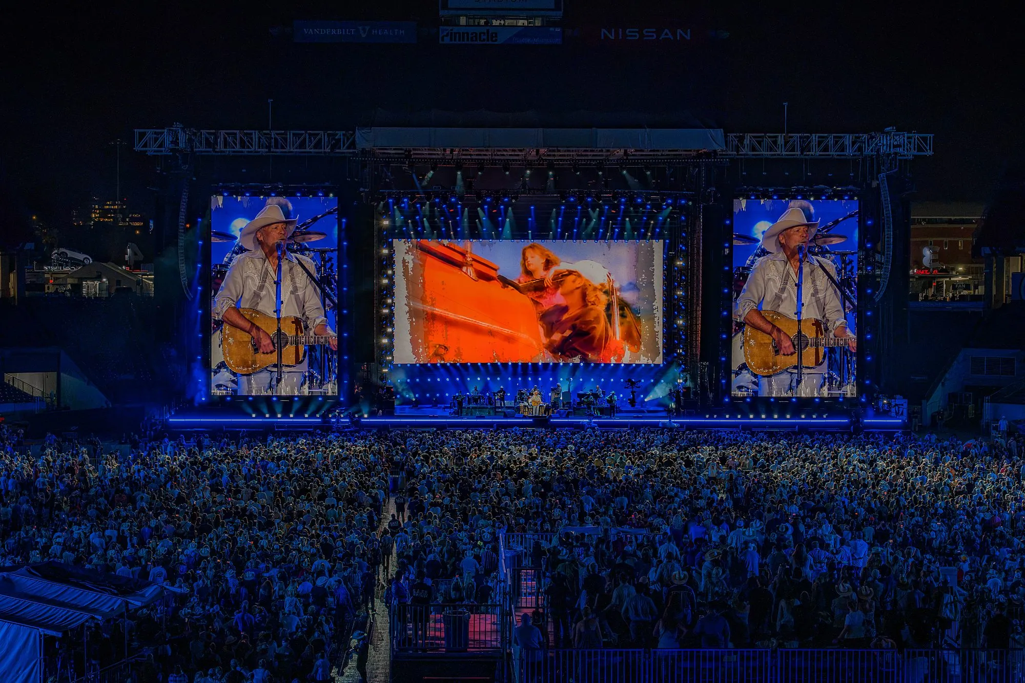 Re-imagined archival footage on the center stadium screen, flanked by live IMAG of Alan Jackson on guitar