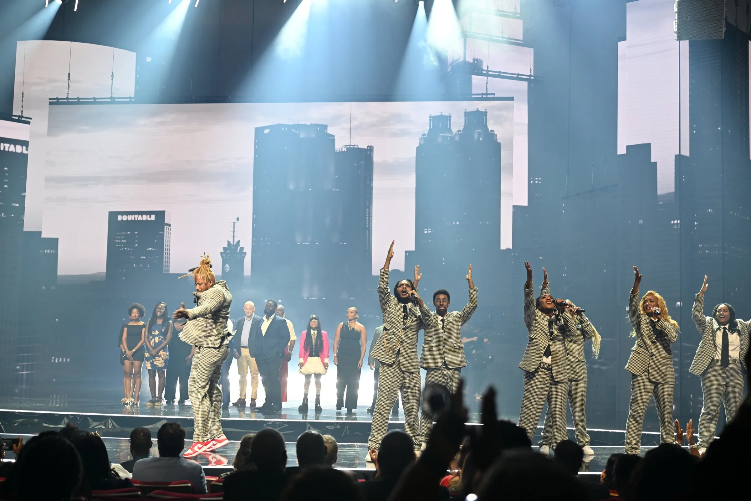 Beloved Benefit gospel performance with the Atlanta skyline rendered in black and white across the back wall and side IMAG screens