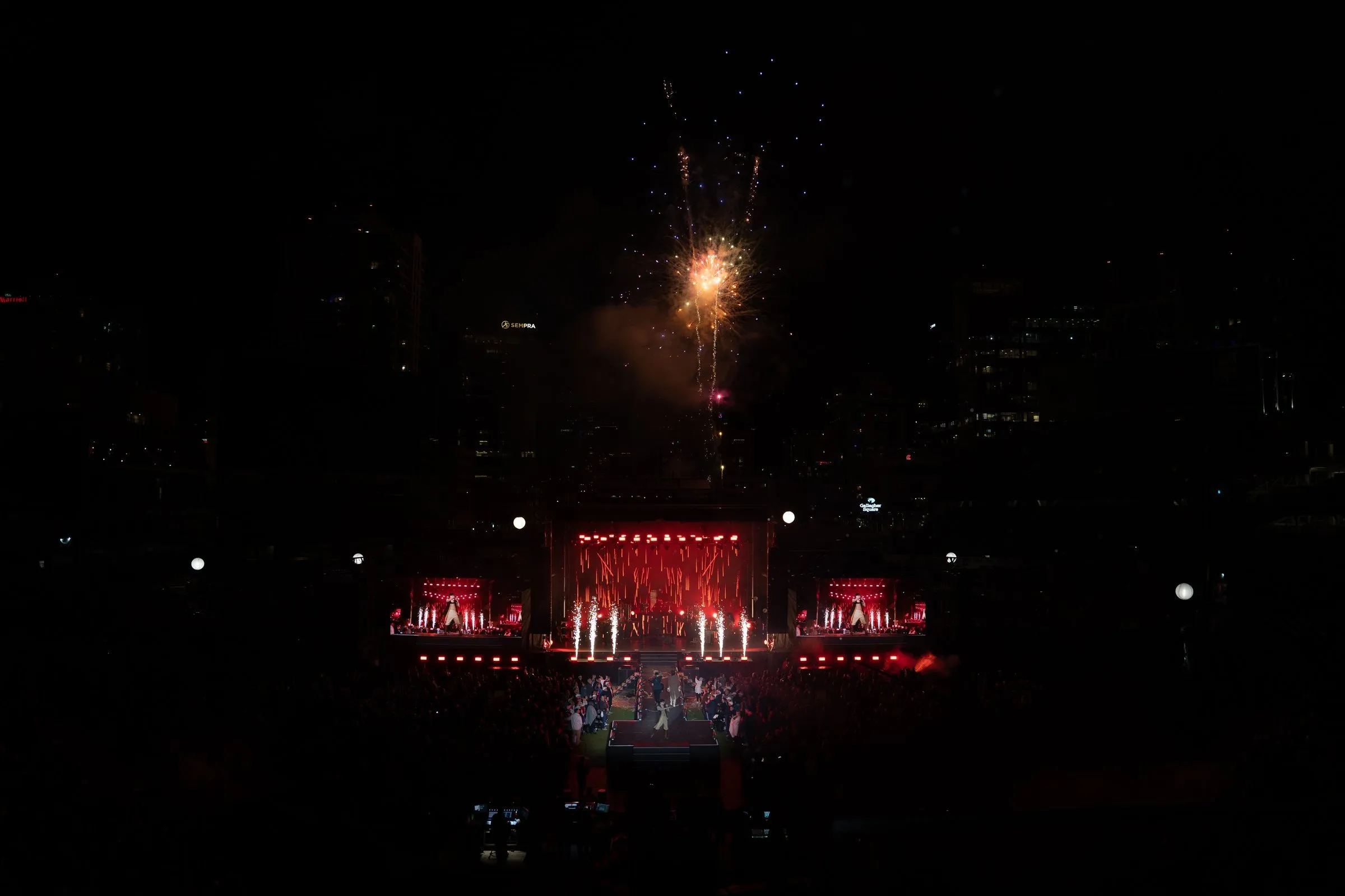 NEXT 2023 — Night of Celebration outdoor stadium show with fireworks above a center stage flanked by IMAG screens