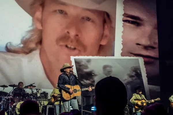 On-stage scrapbook treatment — torn-edge archival polaroids layered behind Alan Jackson and band